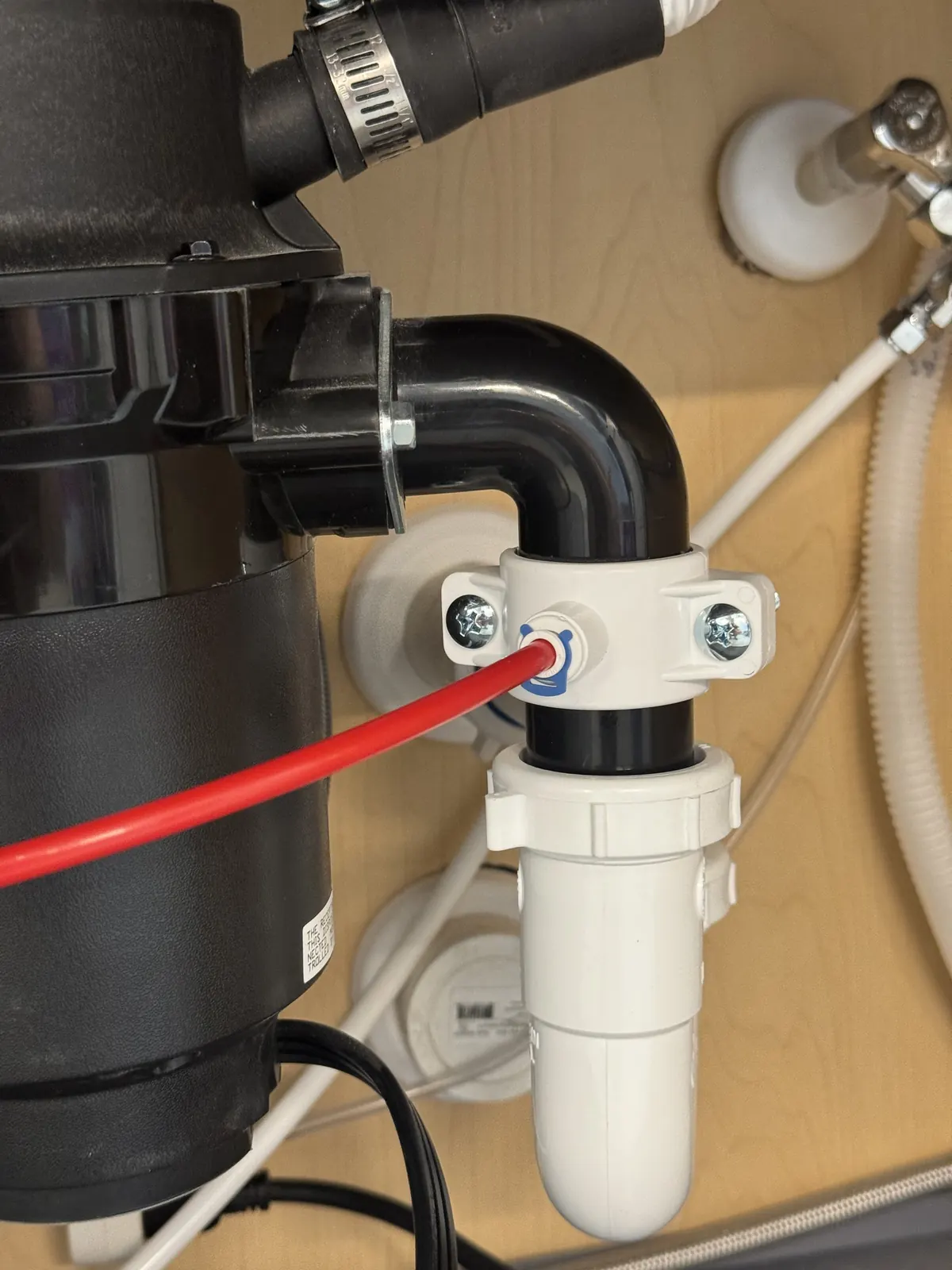 Garbage disposal and drain pipes under a kitchen sink